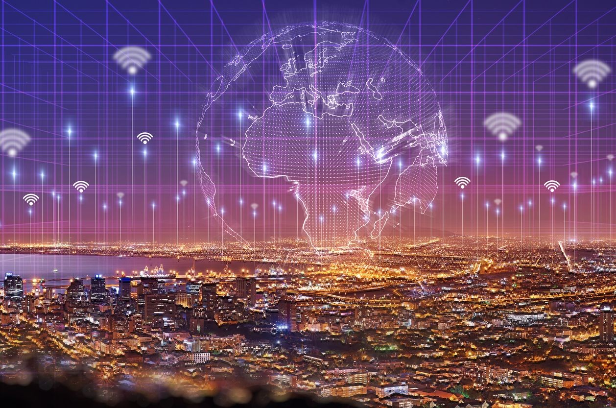 Cityscape at night with a digital globe and wifi symbols, representing global connectivity and network infrastructure.